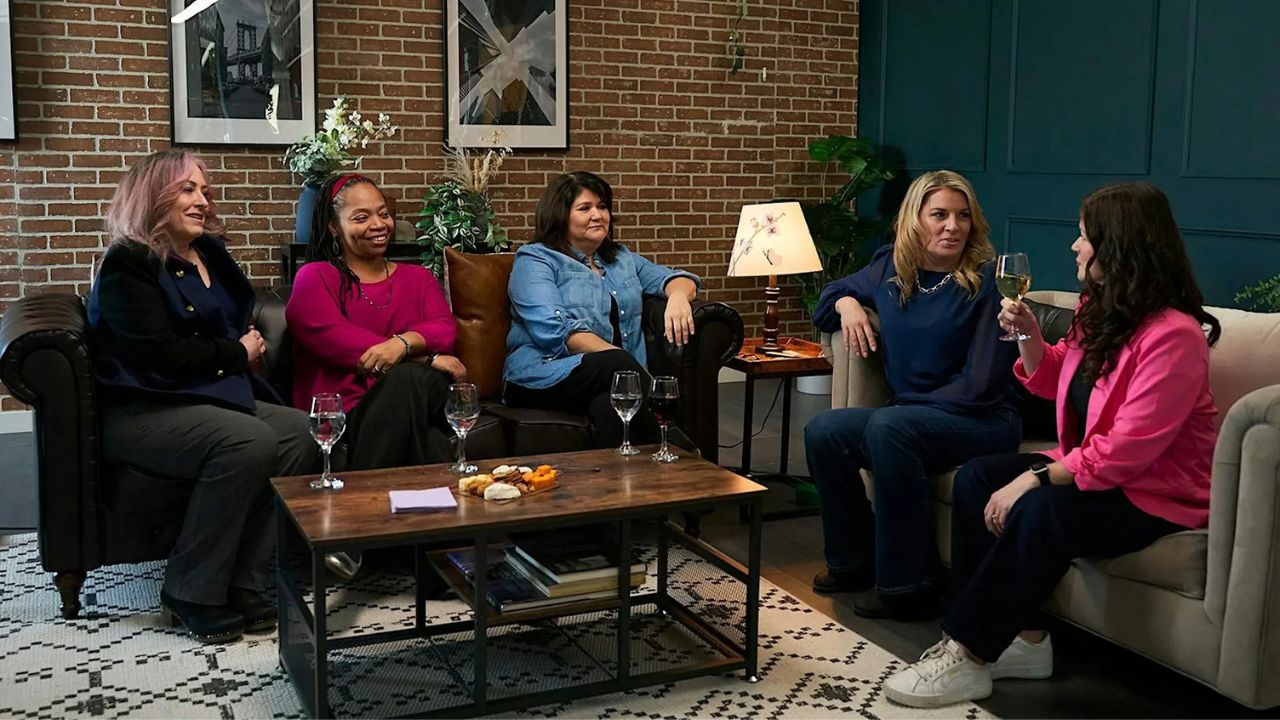 five women talking with glasses of wine
